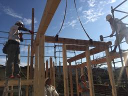 クレーンで梁や桁などの重い木材を吊り上げて柱の上に 取り付けていきます！掛矢と呼ばれる大きな木槌でしっかりと木材を組み付けていきます！---- ©2019 霧島市 TDホーム霧島（有）林工務店 ----